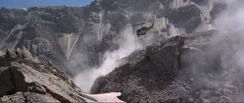 Movie still from “Dante's Peak” (1997), directed by Roger Donaldson – A helicopter is flying over a rocky mountain side; Extreme Wide shot, Low angle