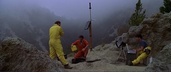 Movie still from “Dante's Peak” (1997), directed by Roger Donaldson – Two men in orange jumpsuits working on a solar panel; Extreme Wide shot, High angle
