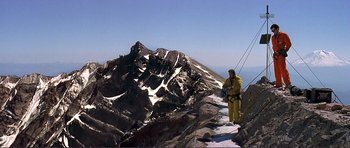 Movie still from “Dante's Peak” (1997), directed by Roger Donaldson – A man standing on top of a snow covered mountain; Extreme Wide shot, Low angle