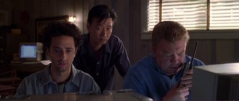 Movie still from “Dante's Peak” (1997), directed by Roger Donaldson – A group of people sitting around a table; Medium shot, Low angle