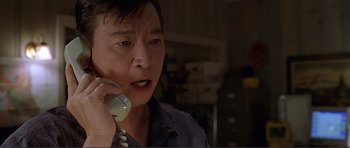 Movie still from “Dante's Peak” (1997), directed by Roger Donaldson – A man talking on a phone in a room; Close Up shot, Low angle