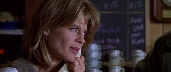 Movie still from “Dante's Peak” (1997), directed by Roger Donaldson – A person sitting at a table; Close Up shot, Low angle