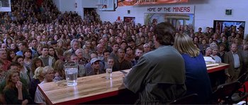 Movie still from “Dante's Peak” (1997), directed by Roger Donaldson – A crowd of people sitting in front of a bar; Wide shot, High angle