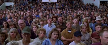 Movie still from “Dante's Peak” (1997), directed by Roger Donaldson – A large group of people sitting in front of a crowd; Wide shot, High angle