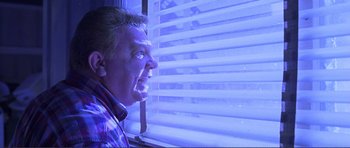 Movie still from “Dante's Peak” (1997), directed by Roger Donaldson – A man looking out of a window at night; Close Up shot, Low angle