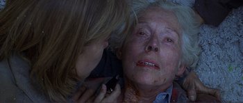 Movie still from “Dante's Peak” (1997), directed by Roger Donaldson – An older woman is holding a cell phone to her ear; Close Up shot, Overhead angle