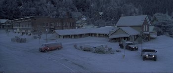 Movie still from “Dante's Peak” (1997), directed by Roger Donaldson – An old car is parked in the middle of a parking lot; Extreme Wide shot, High angle