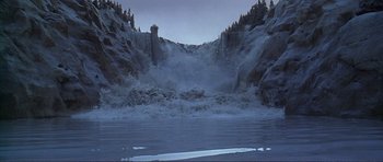 Movie still from “Dante's Peak” (1997), directed by Roger Donaldson – A view of a lake with a waterfall in the middle of it; Extreme Wide shot, High angle
