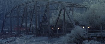 Movie still from “Dante's Peak” (1997), directed by Roger Donaldson – A train traveling across a bridge in the middle of the night; Extreme Wide shot, High angle