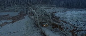 Movie still from “Dante's Peak” (1997), directed by Roger Donaldson – An old bridge is crossing over a snowy river; Extreme Wide shot, High angle