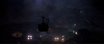 Movie still from “Dante's Peak” (1997), directed by Roger Donaldson – A helicopter is flying over a group of vehicles; Extreme Wide shot, High angle