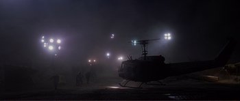 Movie still from “Dante's Peak” (1997), directed by Roger Donaldson – A group of people standing next to a helicopter in the dark; Extreme Wide shot, High angle
