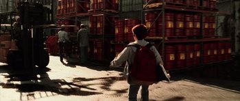 Movie still from “Daredevil” (2003), directed by Mark Steven Johnson – A boy with a backpack walking in a warehouse; Wide shot, High angle