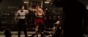 Movie still from “Daredevil” (2003), directed by Mark Steven Johnson – A man in a boxing ring wearing red shorts and gloves; Medium shot, Low angle