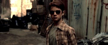 Movie still from “Daredevil” (2003), directed by Mark Steven Johnson – A young man wearing sunglasses and a plaid shirt; Close Up shot, Over the shoulder angle