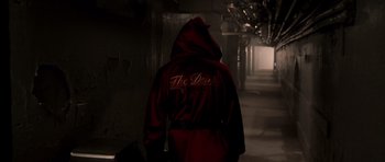 Movie still from “Daredevil” (2003), directed by Mark Steven Johnson – A person wearing a red robe in a dark room; Wide shot, Low angle