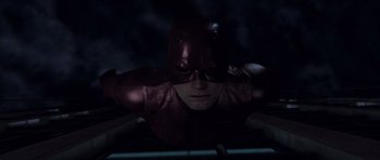 Movie still from “Daredevil” (2003), directed by Mark Steven Johnson – A man wearing a red mask and a red suit; Close Up shot, Overhead angle