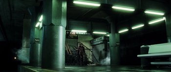 Movie still from “Daredevil” (2003), directed by Mark Steven Johnson – A man standing in front of stairs in a building; Wide shot, Low angle