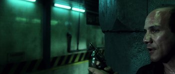 Movie still from “Daredevil” (2003), directed by Mark Steven Johnson – A person holding a gun in a dark room; Close Up shot, Low angle