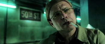 Movie still from “Daredevil” (2003), directed by Mark Steven Johnson – A man with glasses is smoking a cigarette; Close Up shot, Low angle
