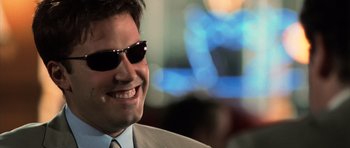 Movie still from “Daredevil” (2003), directed by Mark Steven Johnson – A person wearing a suit and sunglasses; Close Up shot, Low angle