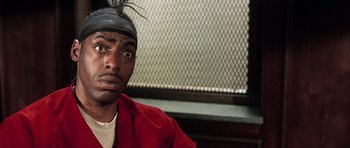 Movie still from “Daredevil” (2003), directed by Mark Steven Johnson – A man in a red shirt and a black hat; Close Up shot, Low angle