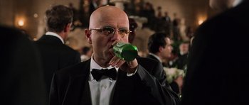 Movie still from “Daredevil” (2003), directed by Mark Steven Johnson – A man in a suit and tie drinking from a green bottle; Close Up shot, Low angle