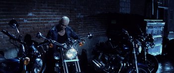 Movie still from “Daredevil” (2003), directed by Mark Steven Johnson – A man sitting on the back of a motorcycle in the dark; Wide shot, Low angle