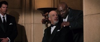 Movie still from “Daredevil” (2003), directed by Mark Steven Johnson – Two men in tuxedos one of them is cutting the other's tie; Medium shot, Low angle
