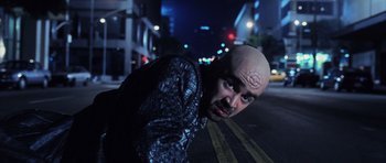 Movie still from “Daredevil” (2003), directed by Mark Steven Johnson – A man with bald head standing in the middle of the street; Close Up shot, Overhead angle