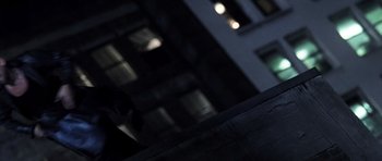Movie still from “Daredevil” (2003), directed by Mark Steven Johnson – A person walking on a sidewalk near a building; Close Up shot, Low angle
