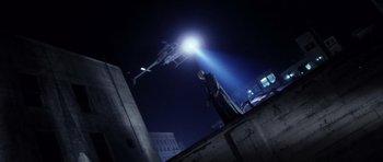 Movie still from “Daredevil” (2003), directed by Mark Steven Johnson – A man standing on top of a building at night under a street light; Wide shot, Low angle