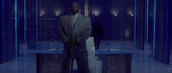 Movie still from “Daredevil” (2003), directed by Mark Steven Johnson – A man in a gray suit standing in front of a window; Wide shot, Low angle