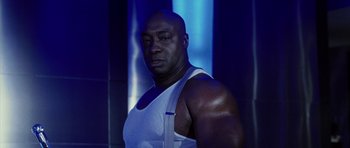 Movie still from “Daredevil” (2003), directed by Mark Steven Johnson – A man in a white tank top is posing for a picture; Close Up shot, Low angle