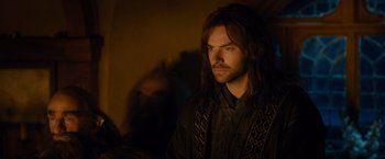 Movie still from “The Hobbit: An Unexpected Journey” (2012), directed by Peter Jackson – A man with long black hair is looking at the camera; Close Up shot, Over the shoulder angle