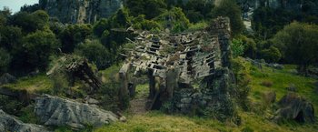 Movie still from “The Hobbit: An Unexpected Journey” (2012), directed by Peter Jackson – An old stone building with many wooden shacks on it's side; Extreme Wide shot, High angle