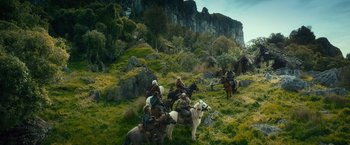 Movie still from “The Hobbit: An Unexpected Journey” (2012), directed by Peter Jackson – A group of people riding horses through a field; Extreme Wide shot, High angle