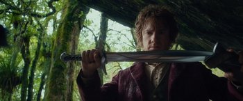 Movie still from “The Hobbit: An Unexpected Journey” (2012), directed by Peter Jackson – A man holding a sword in a forest; Close Up shot, Low angle
