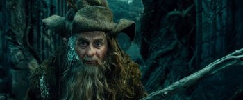 Movie still from “The Hobbit: An Unexpected Journey” (2012), directed by Peter Jackson – A man with a long beard wearing a hat and holding a sword; Close Up shot, Low angle