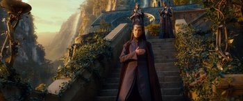 Movie still from “The Hobbit: An Unexpected Journey” (2012), directed by Peter Jackson – A man standing on some steps in front of a waterfall; Wide shot, Low angle