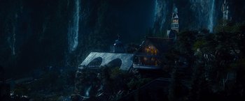 Movie still from “The Hobbit: An Unexpected Journey” (2012), directed by Peter Jackson – A house on a hill with a waterfall in the background; Extreme Wide shot, High angle