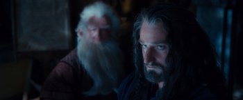 Movie still from “The Hobbit: An Unexpected Journey” (2012), directed by Peter Jackson – A bearded man with a long white beard and an old man with a long white beard and an old man with long white hair; Close Up shot, Over the shoulder angle