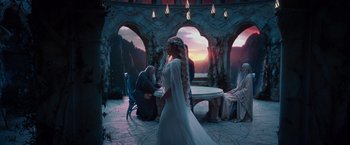 Movie still from “The Hobbit: An Unexpected Journey” (2012), directed by Peter Jackson – A woman in a white dress standing in front of a table; Wide shot, Over the shoulder angle