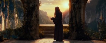 Movie still from “The Hobbit: An Unexpected Journey” (2012), directed by Peter Jackson – A man in a robe standing in front of a sunset; Wide shot, Low angle