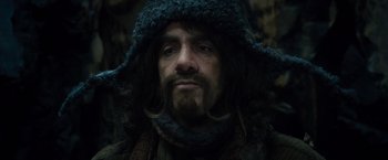 Movie still from “The Hobbit: An Unexpected Journey” (2012), directed by Peter Jackson – A person with a beard wearing a hat; Close Up shot, Over the shoulder angle
