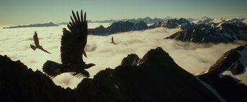 Movie still from “The Hobbit: An Unexpected Journey” (2012), directed by Peter Jackson – Two birds flying over a mountain with clouds in the background; Extreme Wide shot, Low angle