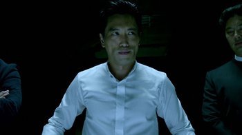 Movie still from “Daredevil” (2015), created by Drew Goddard – A man wearing a white shirt is standing in the dark; Close Up shot, Low angle