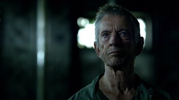 Movie still from “Daredevil” (2015), created by Drew Goddard – An old man with a gray beard looking into the distance; Close Up shot, Low angle