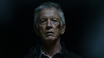 Movie still from “Daredevil” (2015), created by Drew Goddard – An older man with a gray beard and a black shirt; Close Up shot, Low angle