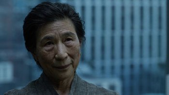 Movie still from “Daredevil” (2015), created by Drew Goddard – An older woman is looking into the camera; Close Up shot, Over the shoulder angle